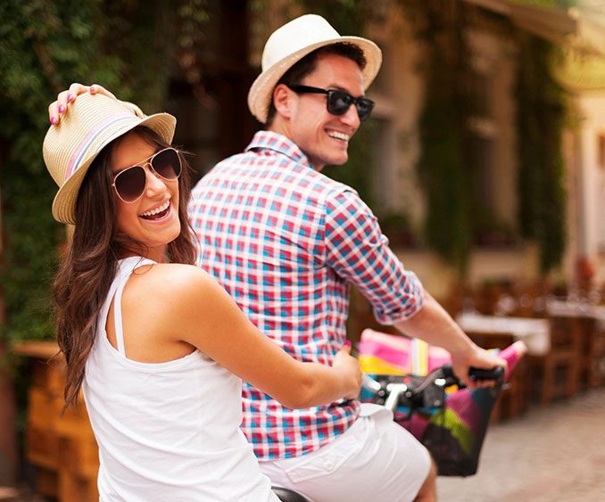 A man and woman riding bikes on the street.