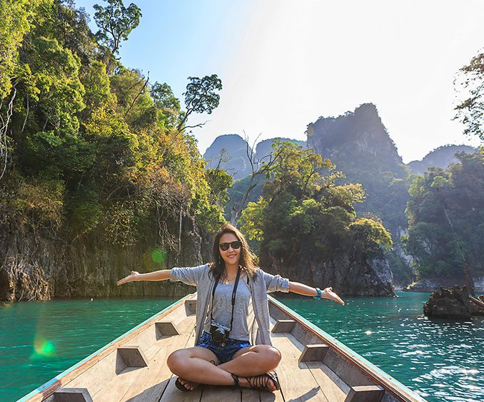 A woman sitting on the back of a boat in the water.