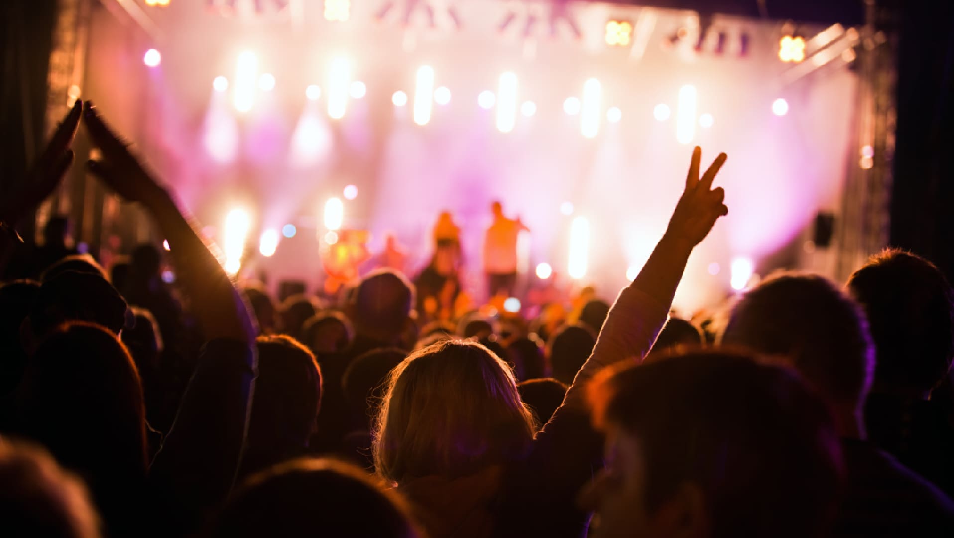 A crowd of people at an event with lights.