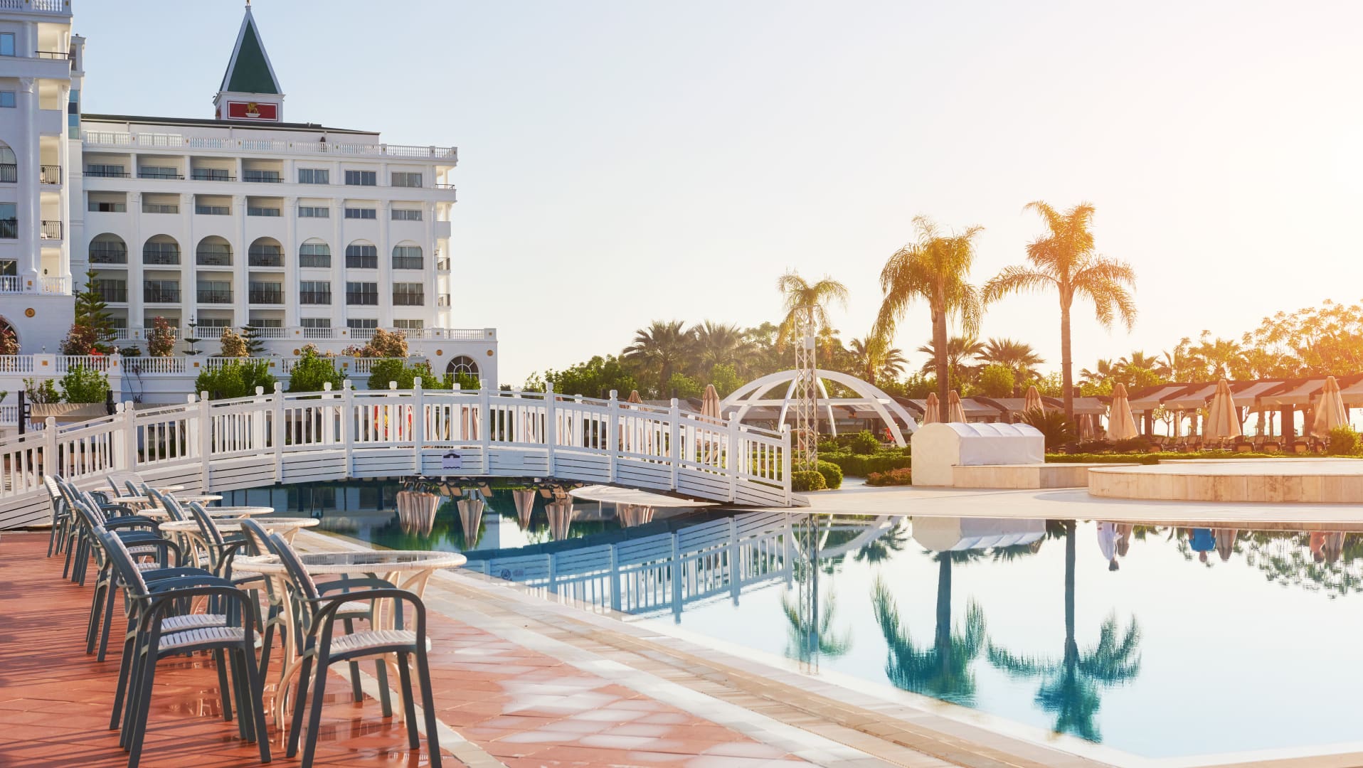 A pool with chairs and a bridge over it