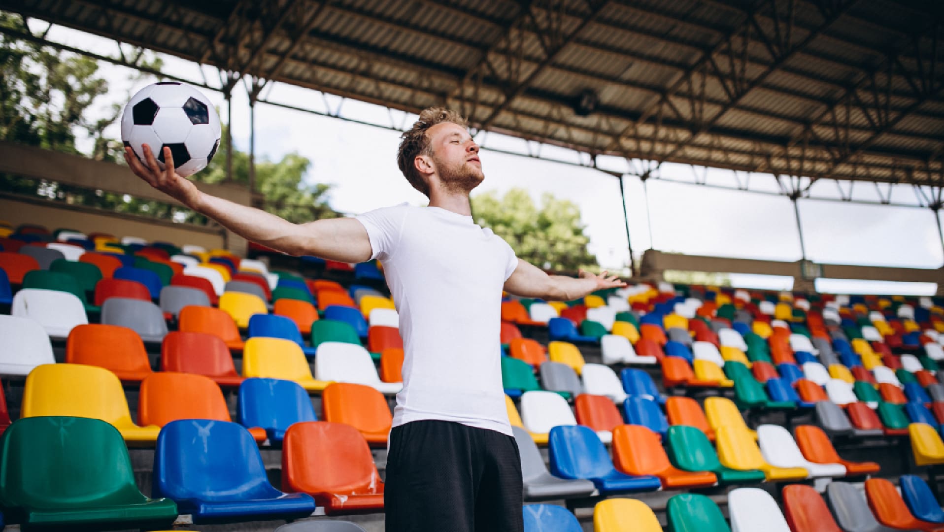 A man standing in front of many colorful seats.